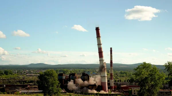Endüstriyel bacanın çökmesi. Eskimiş bir metal bitkisinin eski bir bacasının patlaması.