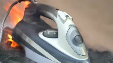 Ütüyü ütülemek için kullan. Ev aletleri alev aldı. Evde bir ev yangını vardı. Yakın plan..