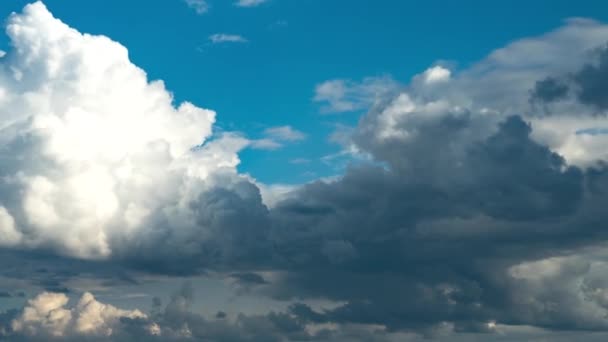 Cambio de clima. En un día soleado brillante, las nubes blancas se mueven rápidamente y son oscurecidas por nubes oscuras — Vídeos de Stock