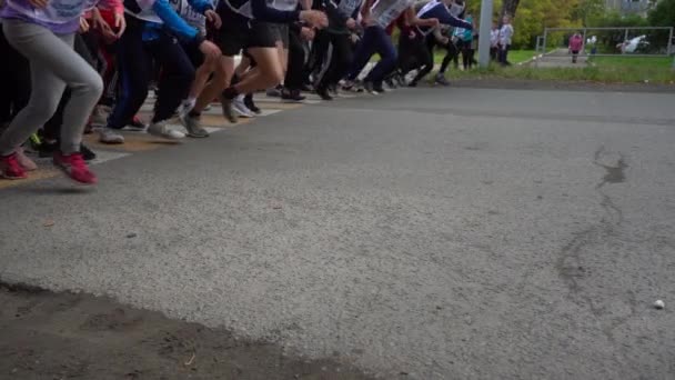 Pernas de jovens corredores no início de uma maratona de corrida. Movimento lento — Vídeo de Stock