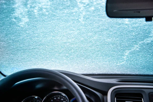 Gefrorene Frontscheibe des Autos. Autoscheibe unter einer Schneeschicht. Innensicht lizenzfreie Stockfotos