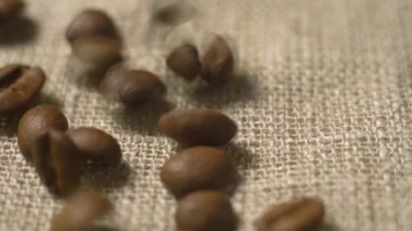 Kahve çekirdekleri kumaşın üzerine düşer. Kahve tohumları düşer. Çuvala dökülecek tahıllı kahvenin kalitesi.