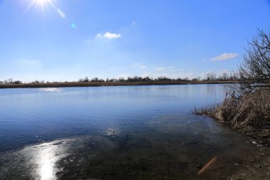 Geç sonbaharda, parlak güneşli bir günde ağaçları ile zaten uçtu yaprakları etrafında ve banka Nehri boyunca kuru sarı, kurutulmuş kamışı
