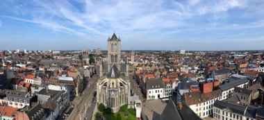 St Nicholas Kilisesi doğru ve Ghent şehir merkezinde eski binaların çatılarının üzerinden Belfrey tepesinden görüntüleyin. Gent, Belçika.