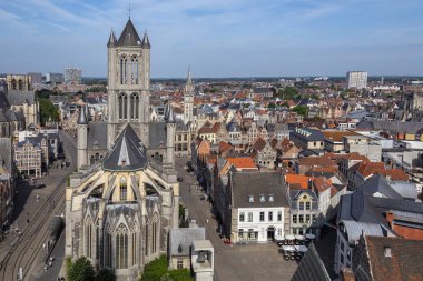 St Nicholas Kilisesi doğru ve Ghent şehir merkezinde eski binaların çatılarının üzerinden Belfrey tepesinden görüntüleyin. Gent, Belçika.