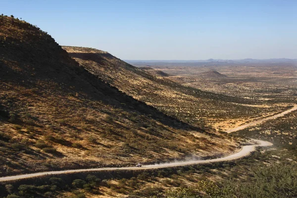 ナミビアのダマラランドをほこりやリモート砂漠の道に沿って運転車両 — ストック写真