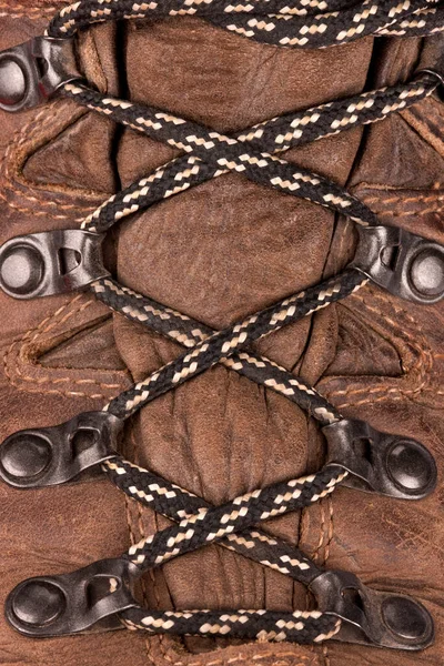 Laced up boots - laces are a cord or leather strip passed through eyelets or hooks on opposite sides of a shoe or garment and then pulled tight and fastened.