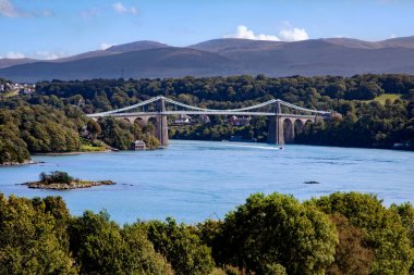 Menai Askılık Köprüsü 'nün Anglesey Adası' ndaki Menai Boğazı 'nın üzerinden Kuzey Galler kıyısı açıklarındaki hava görüntüsü. Köprü 1826 yılında Thomas Telford tarafından tasarlandı ve inşa edildi.