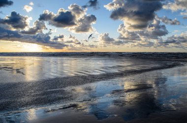 Bulutlu gökyüzü, Baltık denizi, Jurmala, Letonya ile sahilde gün batımı