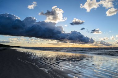 Bulutlu gökyüzü, Baltık denizi, Jurmala, Letonya ile sahilde gün batımı
