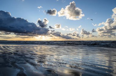 Bulutlu gökyüzü, Baltık denizi, Jurmala, Letonya ile sahilde gün batımı