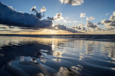 Bulutlu gökyüzü, Baltık denizi, Jurmala, Letonya ile sahilde gün batımı