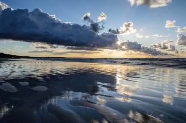 Bulutlu gökyüzü, Baltık denizi, Jurmala, Letonya ile sahilde gün batımı