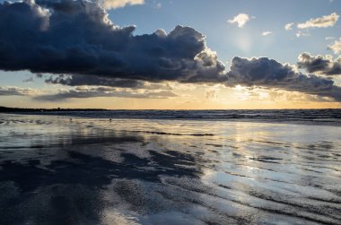 Bulutlu gökyüzü, Baltık denizi, Jurmala, Letonya ile sahilde gün batımı