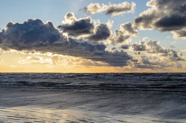 Bulutlu gökyüzü, Baltık denizi, Jurmala, Letonya ile sahilde gün batımı