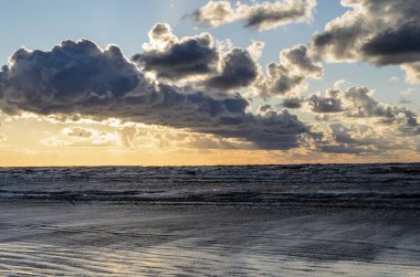 Bulutlu gökyüzü, Baltık denizi, Jurmala, Letonya ile sahilde gün batımı