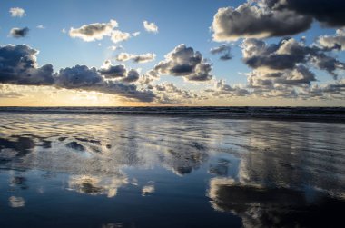 Bulutlu gökyüzü, Baltık denizi, Jurmala, Letonya ile sahilde gün batımı