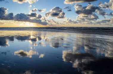 Bulutlu gökyüzü, Baltık denizi, Jurmala, Letonya ile sahilde gün batımı