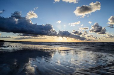 Bulutlu gökyüzü, Baltık denizi, Jurmala, Letonya ile sahilde gün batımı