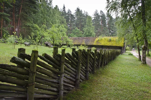 Oud houten huis met rieten dak en houten hek — Stockfoto