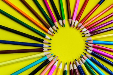 Sarı arkaplan kopya boşluğunda renkli kalemler