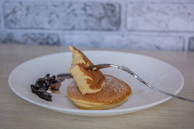 Beyaz tabakta kahvaltılı tatlı gözlemeler tuğla bir duvar