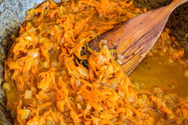 Kızartma tavasında pişirmek için havuç ve soğan.