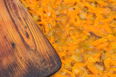 Pişirmek için havuç, soğan ve ahşap bir spatula.