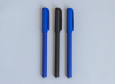 Beyaz arkaplanda mavi ve siyah kalemler