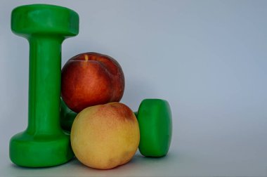 fitness dambılları ve şeftaliler beyaz arka planda yakın plan