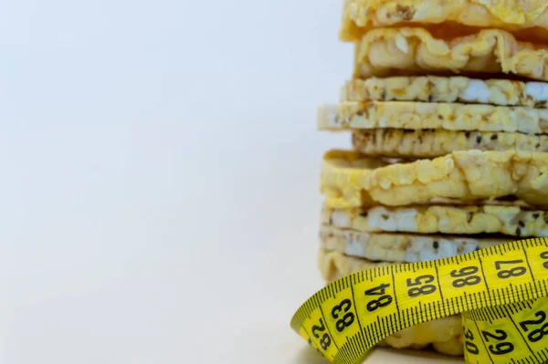 corn and rice cakes fitness food wiht tape measure on a white background copy space