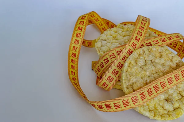 corn cakes fitness food wiht tape measure on a white background isolate