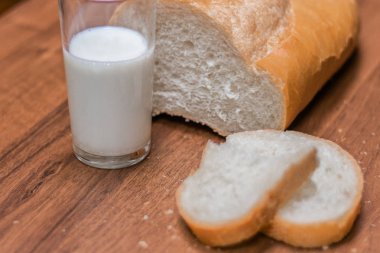 Bir bardak süt ve ekmek ahşap bir masa üzerinde. Yahudi tatil