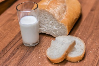 Bir bardak süt ve ekmek ahşap bir masa üzerinde. Yahudi tatil