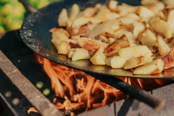 Batatas douradas fritas na grelha. Cozinhar comida na natureza. Cozinhar alimentos em chamas . — Fotografia de Stock