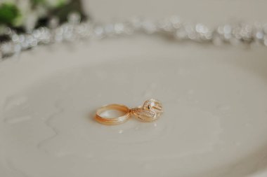 iki altın alyans dik afiş, sevgi ve romantizm sembolize, tebrik veya tebrikler için kopya alanı ile dokulu beyaz payet arka plan üzerinde. Hiç kimse yok