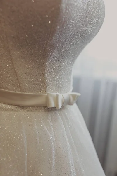 Wedding dress. White wedding dress with a full skirt on a hanger in the room of the bride with white curtains. Wedding attributes. No people. — Stock Photo, Image