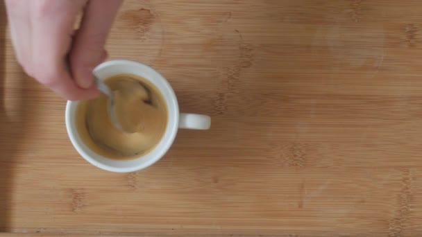 クリーム コーヒーをスプーンでかき混ぜる手と熱いエスプレッソのカップ — ストック動画