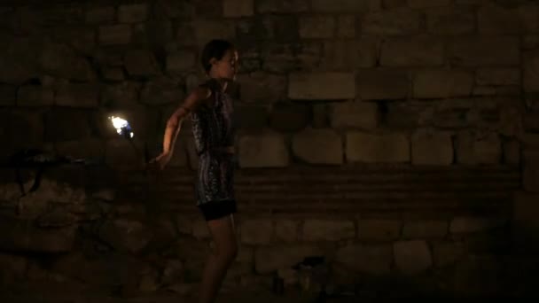 若い魅力的な女性アーティストは 古代都市の壁でダンス火災ショーを実行します — ストック動画