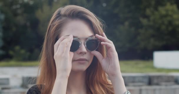 Привлекательная Молодая Женщина Каштановыми Волосами Пирсингом Носа Снимает Стильные Солнечные — стоковое видео
