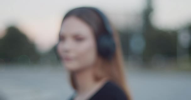 Mladá Žena Naslouchající Hudbě Černých Sluchátkách Rozostřený Efekt Pomalý Pohyb — Stock video