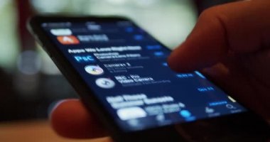 İş ve günlük kullanım için ilginç yararlı uygulamalar için iphone akıllı aygıtı üzerindeki elmalı uygulama mağazasına göz atan kullanıcı