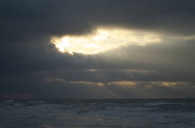 Gün batımında fırtınalı güzel bir deniz manzarası.