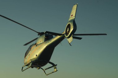 Gün batımında helikopter resmi. Helikopterin silueti...