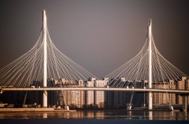 Deniz üzerinde modern bir köprü. St. Petersburg 'da gökyüzüne karşı. Bulutlar, modern binalar ve deniz dalgaları..