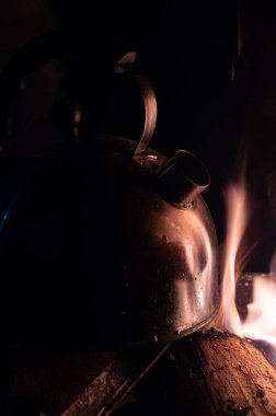 Kömürde kaynayan eski alüminyum çaydanlık ya da buharlı odun sobası.