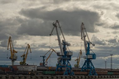 Liman, gün batımında kargo gemileri boşaltılıyor.