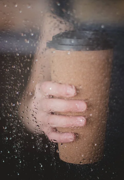 Enjoying coffee on rainy day. Coffee time on rainy day.Wet glass window and cup of hot caffeine beverage.Autumn mood.