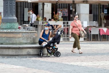 Madrid, İspanya - 8 Ağustos 2020: Madrid şehrinde gün batımında gezen turistler ve aylaklar. İnsanlar kendini Covid-19 'dan korumak için maske takıyor.