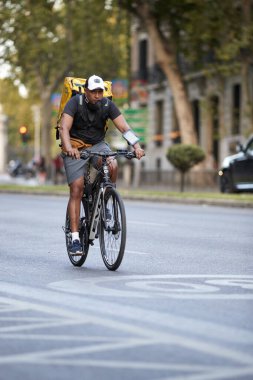 Madrid, İspanya - 8 Ağustos 2020: İşe bisikletle giden bir sürücü kendini Covid-19 'dan korumak için maske takıyor